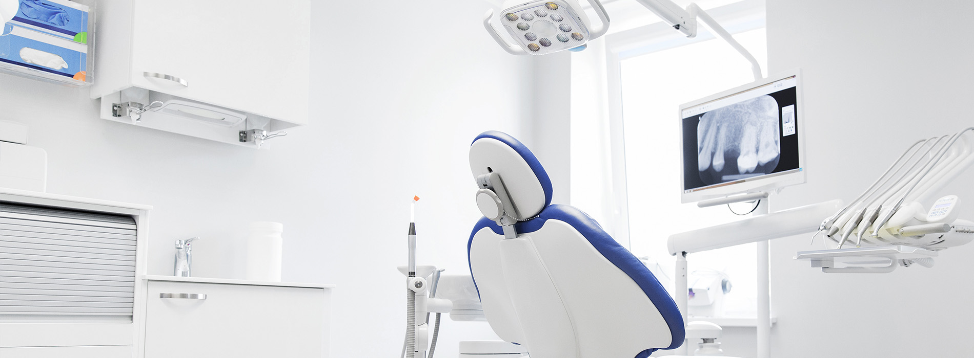 Dental office interior with a modern dental chair and equipment.