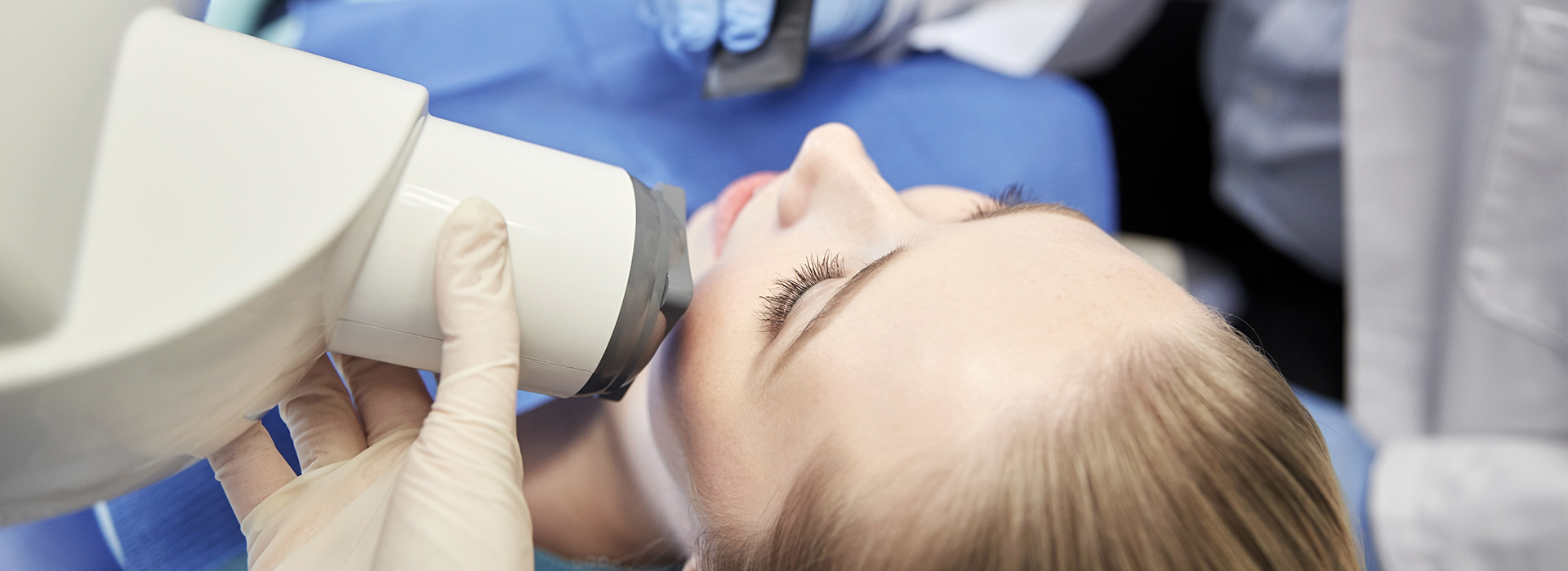 A woman receiving a dental implant procedure, with a dental implant post inserted into her upper jaw.