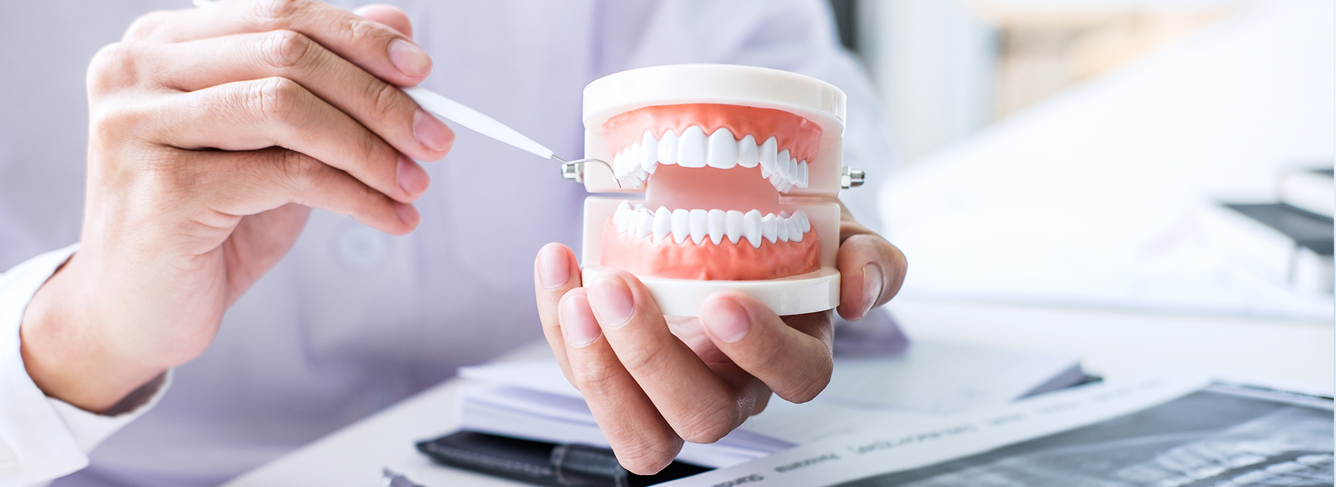 The image shows a person s hand holding a toothbrush with a toothpaste tube, and the hand is placed over a document or paperwork.