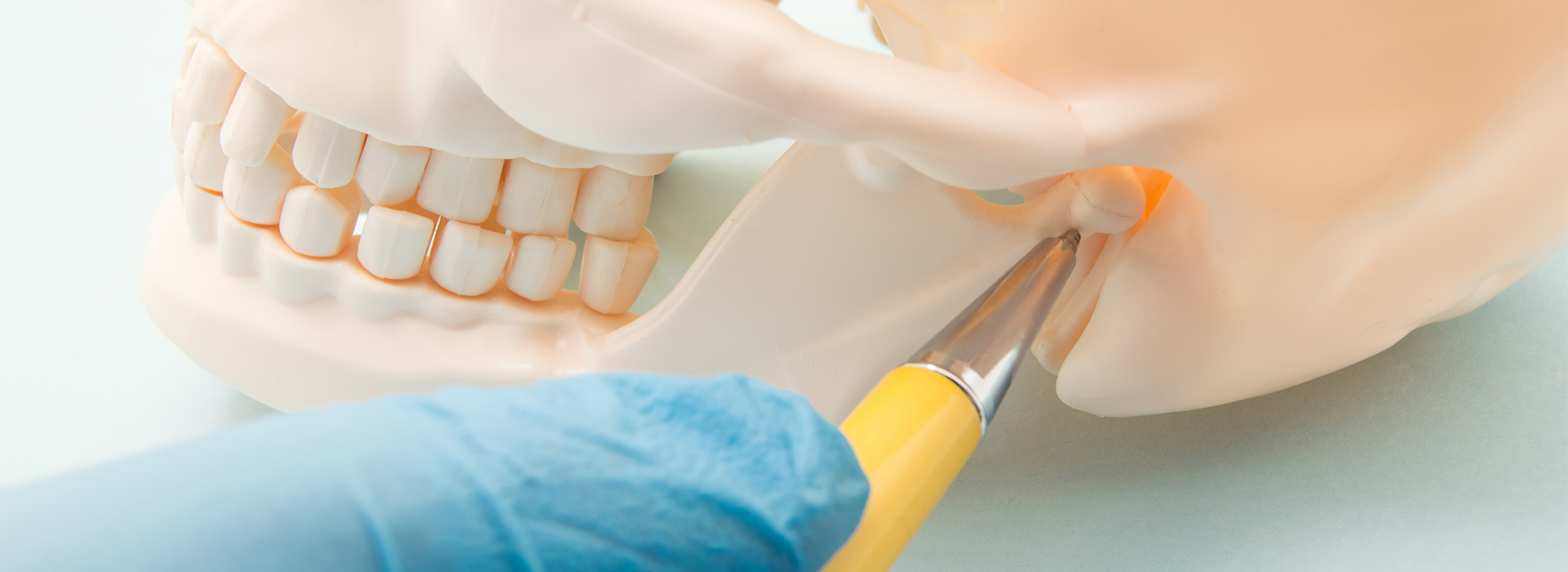 An image of a dental implantation process with a focus on the surgical instrument and the artificial tooth.