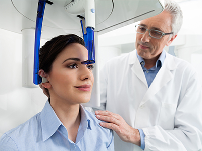 A medical professional assisting a patient with an advanced facial scanner in a modern healthcare setting.