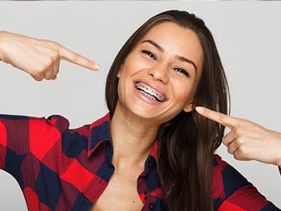 A woman pointing to her nose with a playful expression.